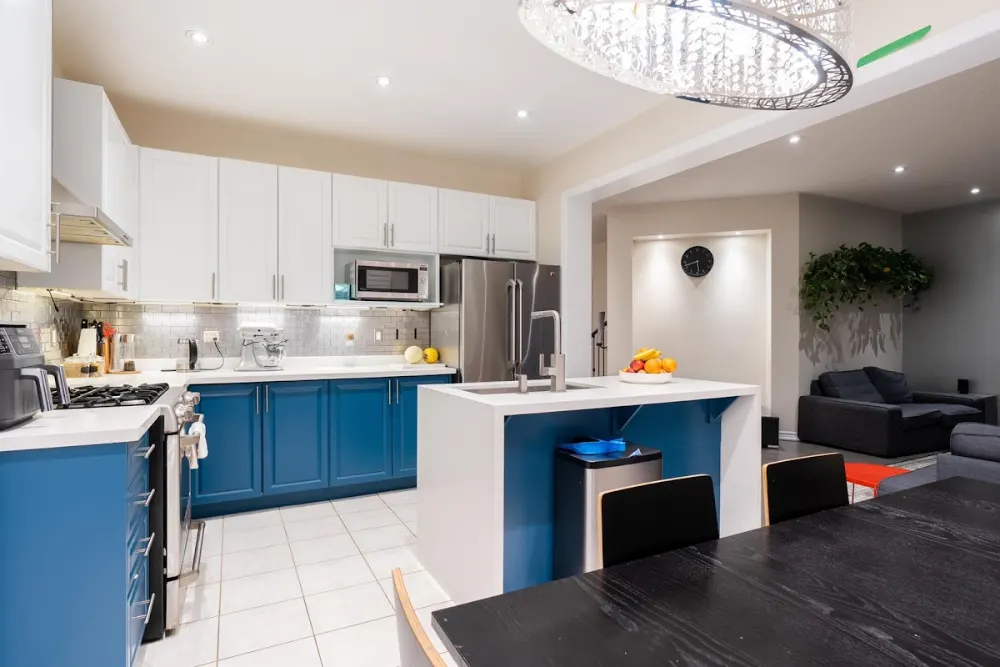 Kitchen with a blue painted island and white cabinets